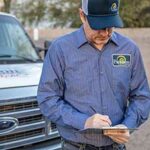 Precision AC Tech reviews work order in front of work truck