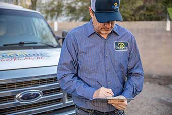 Precision AC Tech reviews work order in front of work truck