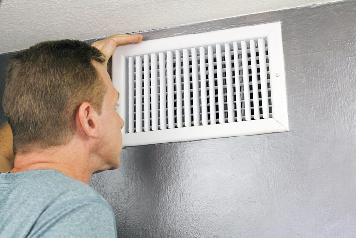 Man inspecting HVAC vent