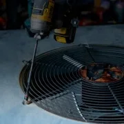 HVAC technician repairing outdoor air conditioner condenser fan
