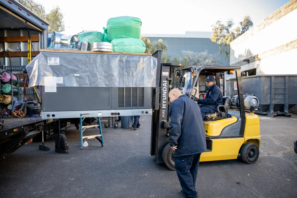 HVAC team unloading rooftop unit
